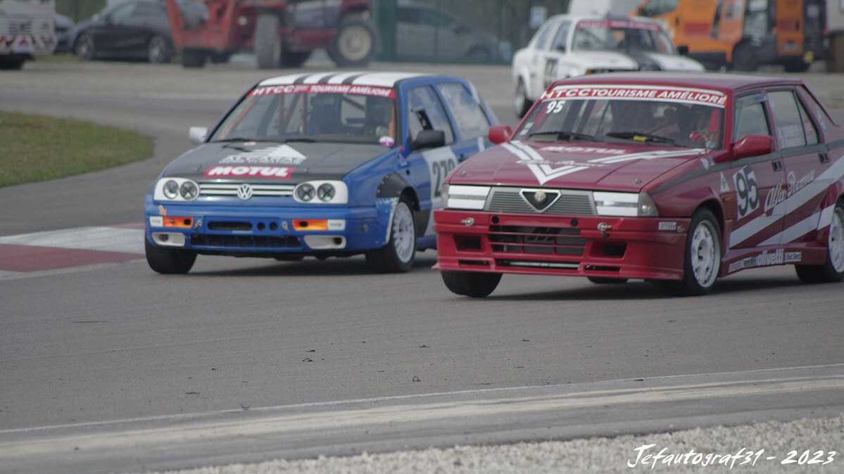 voiture rouge et bleu qui se double sur circuit