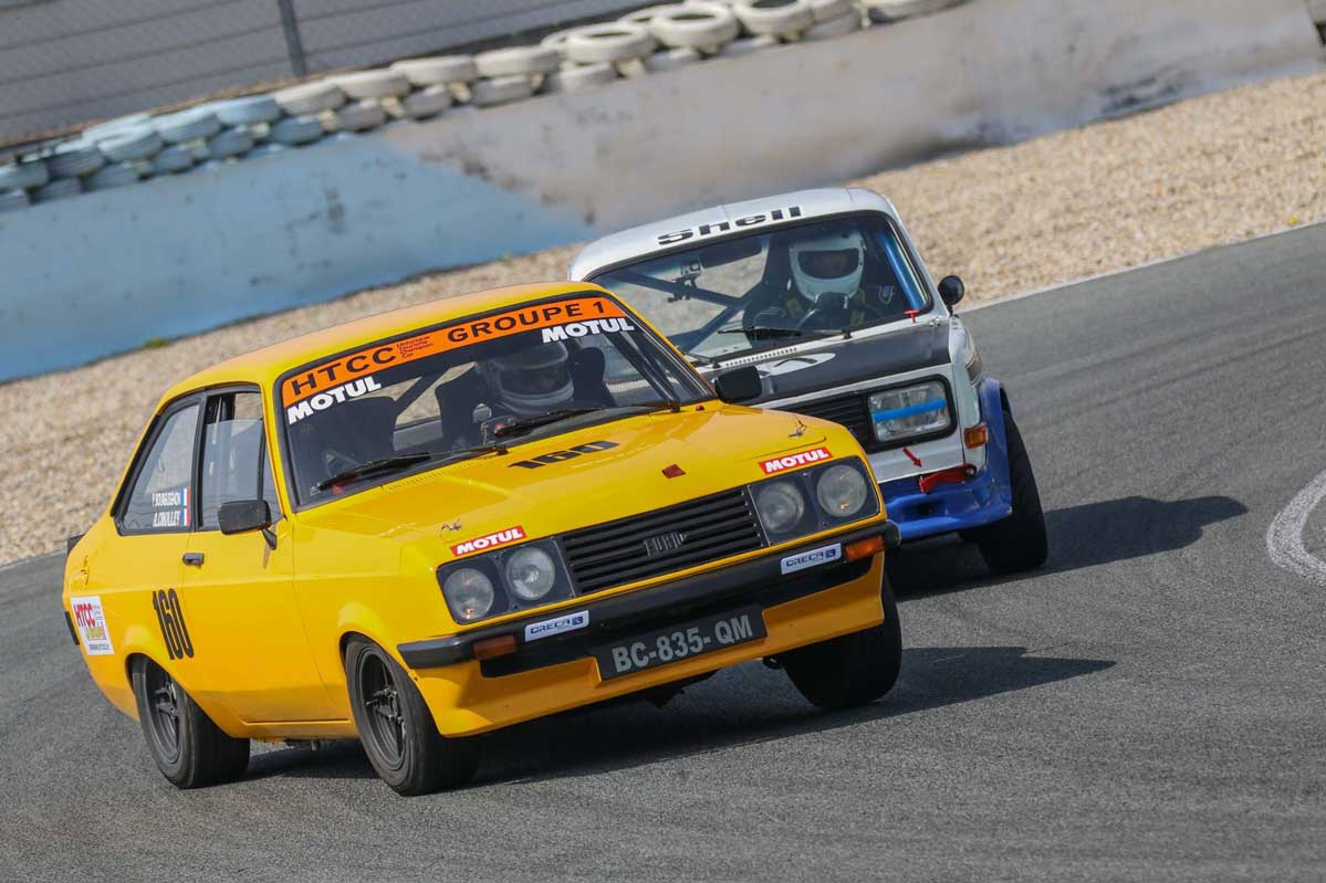 voiture jaune et bleu qui se double sur circuit
